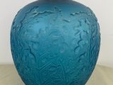 a blue glass vase with a silver lid on a table