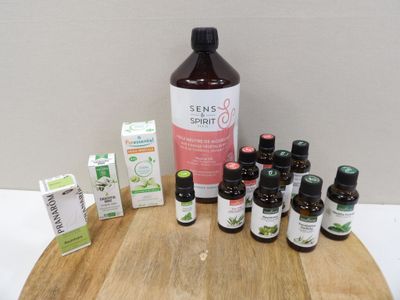 de nombreuses bouteilles d'huiles essentielles posées sur une planche en bois