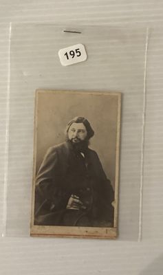 une vieille photo d'un homme barbu vêtu d'un manteau noir