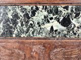 carvings of two birds on a marble panel with a black background