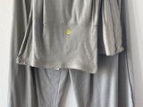 grey top and pants hanging on a hanger on a wall