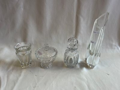 trois objets en verre posés sur une nappe blanche