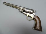 a silver revolver with a wooden handle on a gray surface