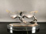 statue of a cat with a fish on a base on a table