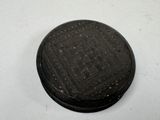 a small black object on a table with a white background