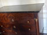 a wooden chest of drawers with a marble top