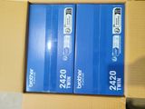 two boxes of blue and white electronic equipment sitting on top of a cardboard box