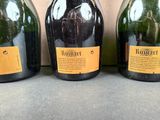 three bottles of wine are lined up on a counter