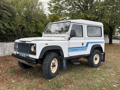 une photo d'un Land Rover blanc garé dans l'herbe