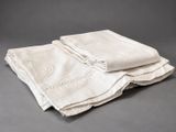 three folded linen napkins on a gray background