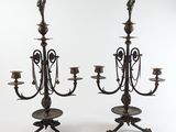 une paire de chandeliers anciens en laiton avec des bougies posées sur des socles