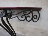 a small table with a red top on the side of a building