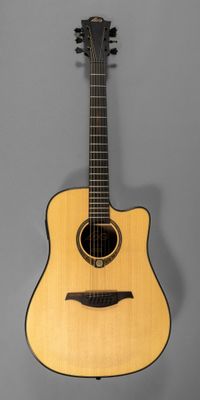 a small acoustic guitar hanging on a wall