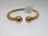 un bracelet en or orné de deux boules et muni d'une étiquette de prix