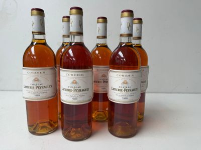 four bottles of wine are lined up on a white surface