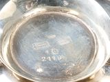 a silver plate with a silver handle on a table