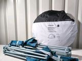 a pile of umbrellas and a bag sitting on a table
