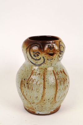 a small vase that has a brown and white design on it