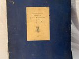 an old book sitting on top of a white cloth covered table