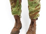 a close up of a person wearing camouflage pants and combat boots