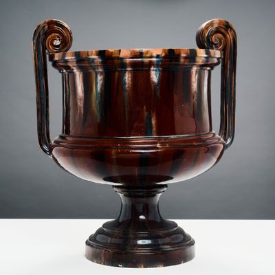 l'image d'un vase brun posé sur une table blanche