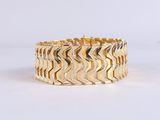 gros plan d'un bracelet en or sur fond blanc