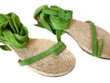pair of women ' s sandals with a green ribbon on them