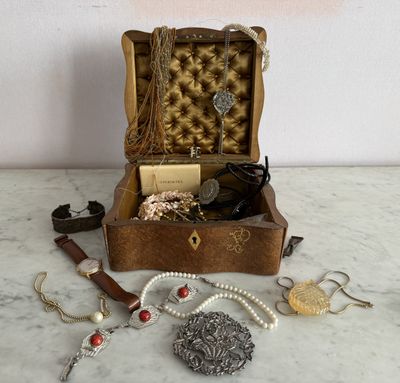 une boîte en bois contenant tout un tas de bijoux