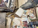 a pile of old books on the floor next to a pile of papers