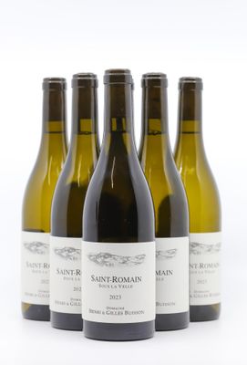 quatre bouteilles de vin sont alignées sur une surface blanche