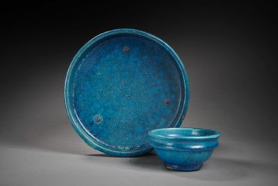 two blue bowls and a bowl sitting on a gray surface