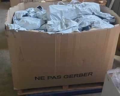 une boîte en carton remplie de matière plastique bleue, posée sur une palette