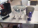 une table blanche sur laquelle se trouvent une horloge et un bol en verre