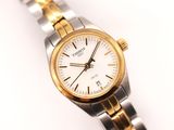 une image d'un gros plan d'une montre-bracelet sur une surface blanche