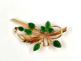 broche de couleur dorée ornée de feuilles vertes
