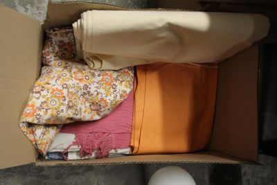 une boîte pleine de vêtements posée sur le sol