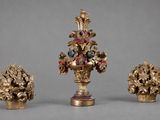 trois vases, chacun contenant des fleurs, posés sur une table