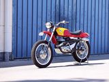 a red and yellow motorcycle parked in front of a blue garage door