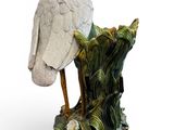 a statue of a bird sitting on top of a tree stump
