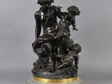 a bronze statue of a woman sitting on a rock with a dog