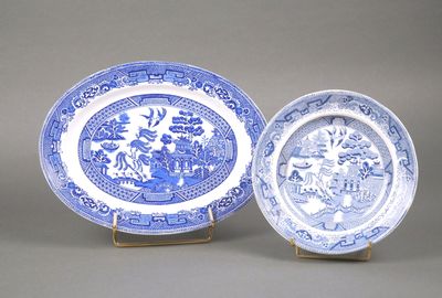 deux assiettes bleues et blanches ornées de motifs, posées sur un présentoir