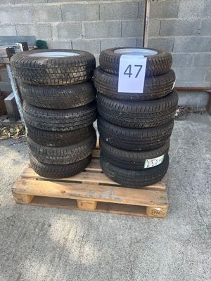 four tires stacked on a pallet in front of a brick wall