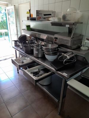 de nombreuses casseroles et poêles posées sur le plan de travail de la cuisine