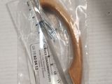 a wooden object in a plastic bag next to a ruler