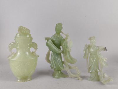 trois figurines en jade représentant des personnages asiatiques et un vase, posés sur un fond blanc