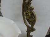 a white vase with a gold handle and a white vase with a flower on it