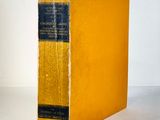 an old book sitting on top of a white table next to a white wall