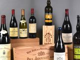 several bottles of wine are lined up in a row next to a wooden box