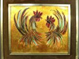 painting of two roosters in a golden frame on a wall