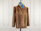 une photo d'un manteau de fourrure marron posé sur un mannequin